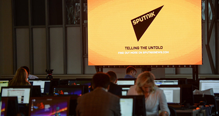 Экран с символикой Международного информационного агентства и радио Sputnik (Спутник). Экран с символикой Международного информационного агентства и радио Sputnik (Спутник).